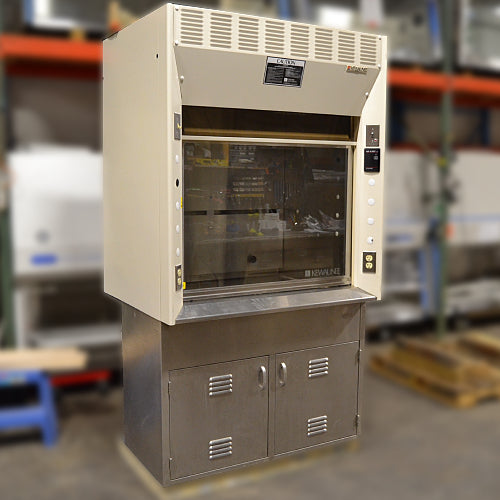 Front-angled studio view of a Kewaunee 4-foot laboratory fume hood showing its beige superstructure, sliding glass sash, side utility panels with electrical outlets, and a stainless steel storage base cabinet with louvered doors