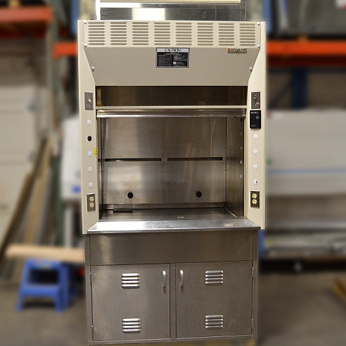 Straight-on low-angle studio view of a Kewaunee 4-foot laboratory fume hood showing the stainless steel work surface, open sliding sash, side utility panels with electrical outlets, and the stainless steel storage cabinet below