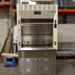 Straight-on low-angle studio view of a Kewaunee 4-foot laboratory fume hood showing the stainless steel work surface, open sliding sash, side utility panels with electrical outlets, and the stainless steel storage cabinet below