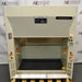 A 4-foot wide Kewaunee Supreme Air chemical fume hood with a solid white color, featuring a black epoxy work surface, standard base cabinets, and control knobs on the sides.