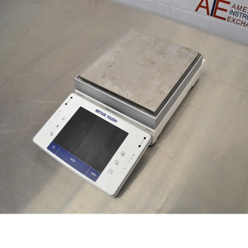 Left-side perspective view of the Mettler Toledo XPE2002S precision balance displaying the touchscreen controller angled towards the front and the stainless steel weighing pan.