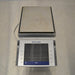 Top view of a Mettler Toledo XPE6002S precision balance with a large rectangular weighing pan and digital touchscreen control terminal.
