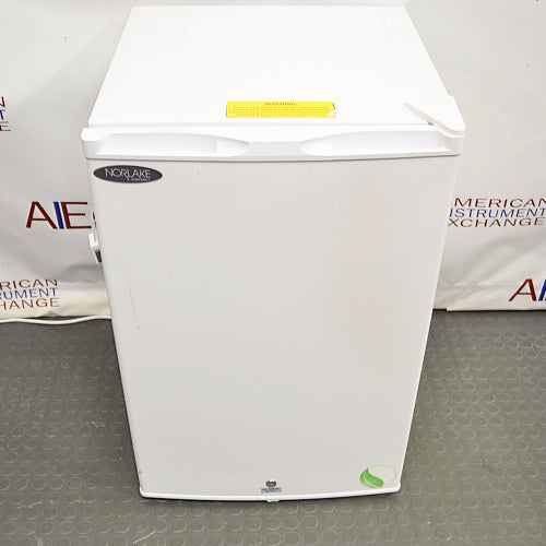Compact white Norlake undercounter laboratory freezer with a solid front door and key lock.