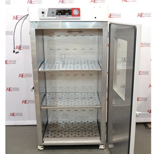 Open front view of a Shel Lab 2428 CO2 incubator showing stainless steel interior shelves and open door.