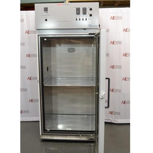 A straight-on open-door view of a Thermo Forma 3940 refrigerated environmental chamber in front of an American Instrument Exchange backdrop, displaying the open outer door, inner glass door, interior stainless steel chamber with shelving, and top grey control console.
