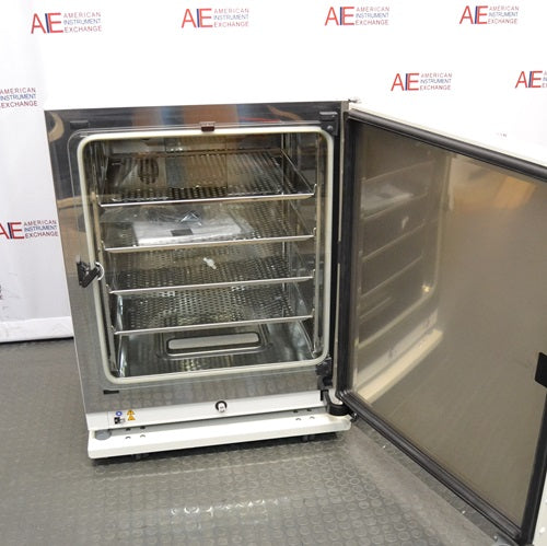 An open front view of a Thermo Heracell VIOS 250i LK CO2 incubator with its outer door swung wide open, revealing the inner glass door, stainless steel interior chamber, and multiple metal shelves inside.