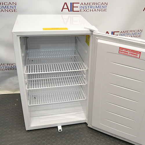 Open interior view of Norlake Scientific undercounter laboratory refrigerator with wire shelves and door warning label