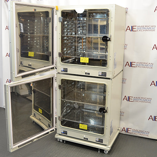 Open interior view of stacked Panasonic cellIQ CO2 laboratory incubators showing inner glass doors and stainless steel shelves