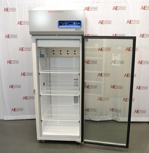An open interior view of a Thermo Scientific TSX2305CA chromatography refrigerator available from American Instrument Exchange, showing the open glass door, wire interior shelving, and inner chamber setup.