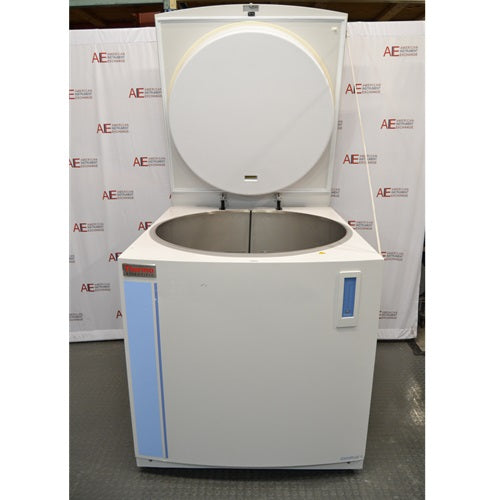 An open-lid front view of a Thermo Scientific CryoPlus 4 cryogenic storage system in front of an American Instrument Exchange backdrop, displaying the raised top lid, circular lid insulation pad, open circular inner stainless steel cryogenic chamber, and front casing.