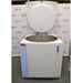 An open-lid front view of a Thermo Scientific CryoPlus 4 cryogenic storage system in front of an American Instrument Exchange backdrop, displaying the raised top lid, circular lid insulation pad, open circular inner stainless steel cryogenic chamber, and front casing.