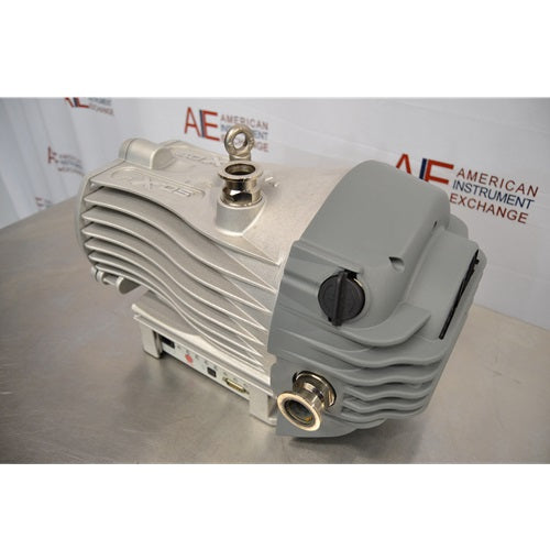 A rear-angled perspective of the Edwards nXDS 10i dry scroll vacuum pump, showcasing the grey protective housing, metal ports, and ribbed metallic body against an American Instrument Exchange backdrop.