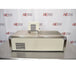 A rear view of a Thermo Scientific A10B refrigerated bath circulator sitting on a stainless steel surface against an American Instrument Exchange backdrop, showing the back casing with square ventilation grid, stainless steel edge trim, top bath opening, and the rear housing of the digital control head.