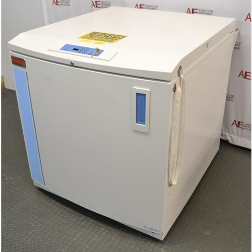 A right-angled view of a Thermo Scientific CryoPlus 4 cryogenic storage system, showing its closed lid with control panel and key lock, front panel with level gauge and blue vertical accent, and right side casing with attached hanging strap.
