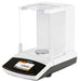 Left-angled view of a Sartorius Secura SECURA125-1S semi-micro balance showing the color touchscreen display with a digital readout, white housing, and enclosed glass draft shield chamber with weighing pan.