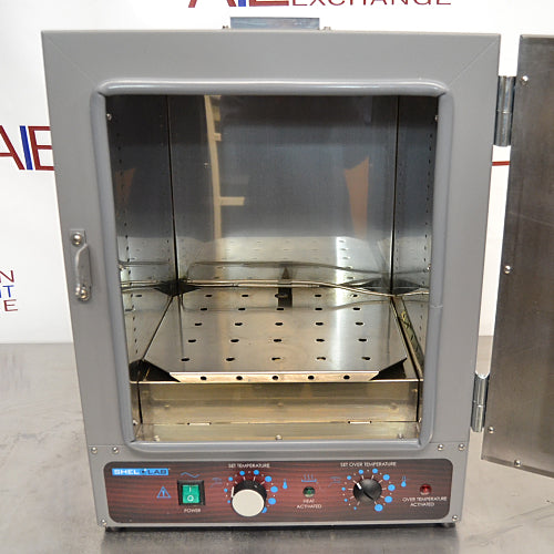 A gray Shel Lab SGO1E Economy Gravity Oven with a front door, control panel, and a caution sticker.