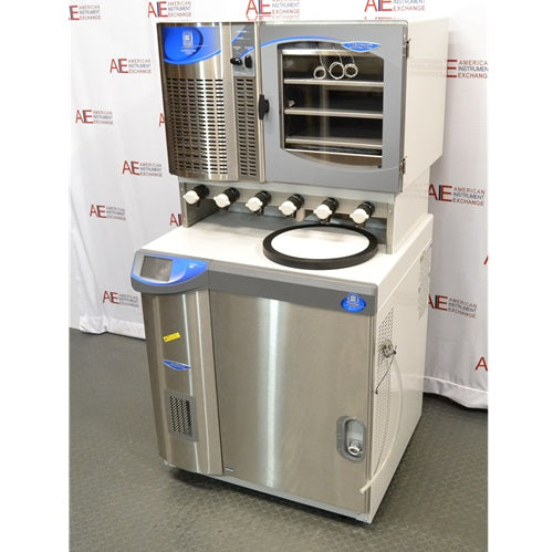 A side-angled view of the Labconco FreeZone 6-liter freeze dryer system and its attached stoppering tray dryer, highlighting the unit's stainless steel finish, drying ports, and control interface against an American Instrument Exchange backdrop.