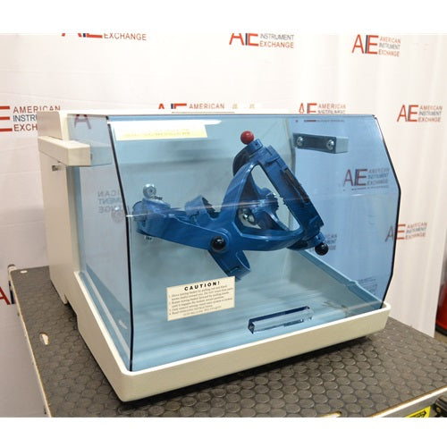 A side-angle view of the Willy A. Bachofen TURBULA T2 three-dimensional shaker mixer with its blue transparent safety shield, standing in front of an American Instrument Exchange backdrop.