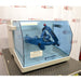 A side-angle view of the Willy A. Bachofen TURBULA T2 three-dimensional shaker mixer with its blue transparent safety shield, standing in front of an American Instrument Exchange backdrop.