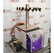 An angled side view of an SP Scientific BenchTop Pro freeze dryer sitting on a benchtop, showing the purple front control panel, side ventilation panel, top multi-port tree manifold, orange vacuum hose, and an attached vacuum pump in the foreground.
