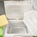Stirling ULT25NEU portable ultralow freezer on a textured surface with a vibrant green and white housing, control panel, and Stirling Ultracold logo.