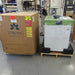 Warehouse view of a Stirling Ultracold SU105UE freezer next to its branded cardboard shipping carton on wooden pallets.