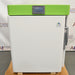 Front-facing studio view of a Stirling Ultracold SU105UE undercounter ultralow freezer featuring a white body, green top bezel with a digital display, and Stirling Ultracold branding.