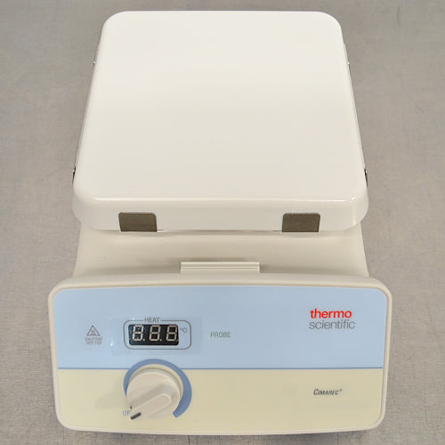 High-angle studio view of a Thermo Scientific Cimarec+ hot plate resting on a metallic work surface, displaying the white ceramic top heating plate, front control panel with digital LED display, and rotary dial