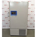A full-length view of a grey Thermo Scientific RDE60086FA ultra-low temperature freezer, featuring a blue digital control panel and front grille, standing in front of an American Instrument Exchange backdrop.