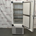 Straight-on studio view of a Thermo Scientific TSX40086 upright ultralow temperature freezer standing on a grey floor against a branded backdrop, featuring a solid grey outer door, ergonomic handle, integrated blue digital touchscreen interface, TSX Series branding, and a lower perforated ventilation panel
