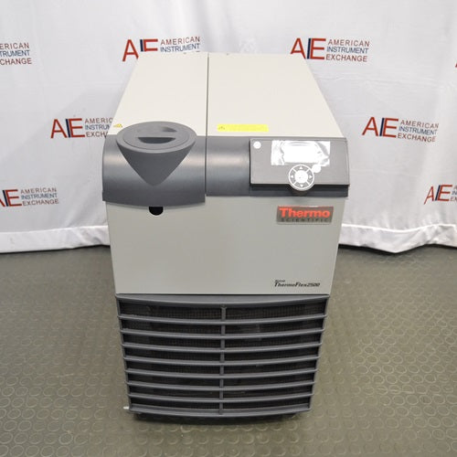A front-facing view of the Thermo Scientific ThermoFlex 2500 recirculating chiller, model TF25 DW 200-230GL, featuring its beige and grey housing, digital control interface, and lower ventilation grille, positioned in front of an American Instrument Exchange backdrop.