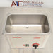 Elevated front view of a Tuttnauer Clean & Simple CSU1H ultrasonic cleaner showing the empty stainless steel cleaning basin, central drain port, and front control switches.