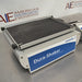 Three-quarter side-angled studio view of the VWR Advanced Dura-Shaker base unit resting on a stainless steel surface, featuring its front blue branding panel and top non-skid platform with securing clamps
