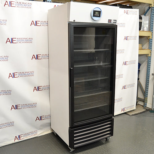 Three-quarter left-angled studio view of a VWR HCLS-26 upright laboratory refrigerator standing on casters against a branded backdrop, featuring a glass door with a black frame, top-mounted digital display console, and louvered bottom grille