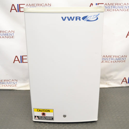 A white VWR undercounter laboratory refrigerator with a blue logo, standing on a floor with 'CAUTION' and 'SERVICE内部使用禁止' stickers on it.
