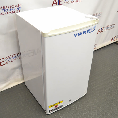 A white VWR freestanding undercounter freezer with a closed door, set against a backdrop featuring the 'American Instrument Exchange' logo.