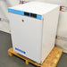 Right angled perspective view of an AccuCold ACR45L undercounter healthcare all-refrigerator on a wooden pallet, showcasing its white cabinet housing, solid locking door, and upper blue control console with digital displays