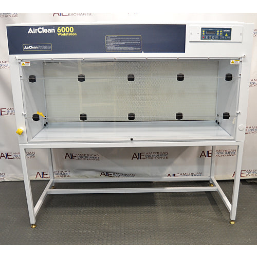 Front product view of an AirClean 6000 HLF horizontal laminar flow clean bench, featuring its white housing, dark blue upper control console, digital display, clear glass side and back panels, and supporting metal frame stand