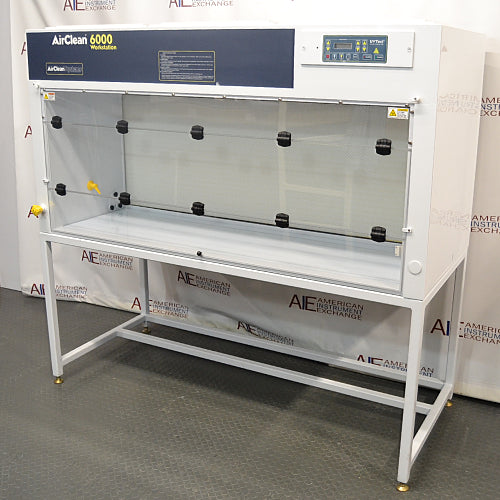Left three-quarter angle product view of an AirClean 6000 HLF horizontal laminar flow clean bench, featuring its white structure, dark blue front upper console, digital control panel, clear side panels, and metal support frame stand