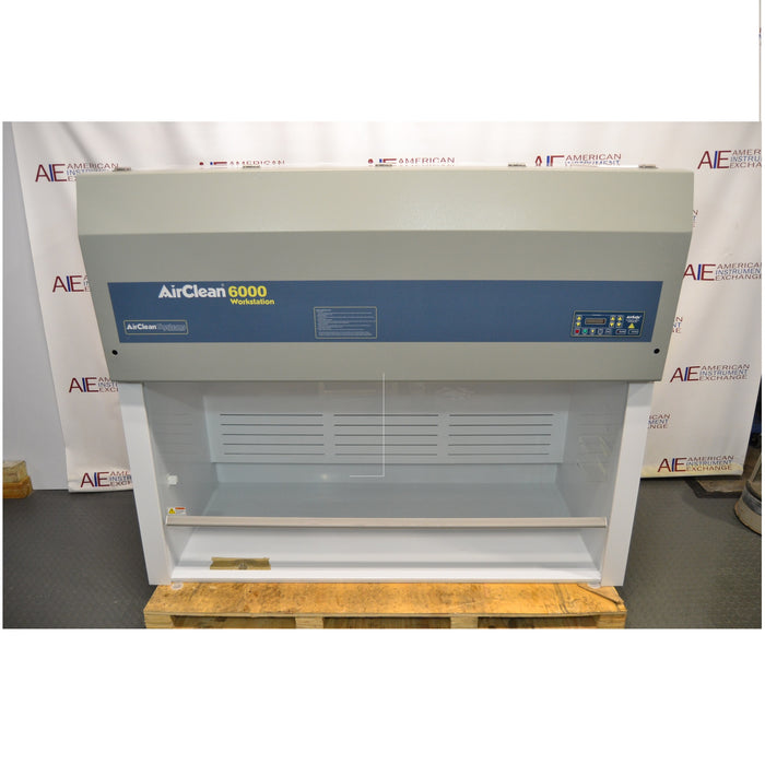 Front eye-level view of an AirClean Systems AC6000S polypropylene ductless fume hood mounted on a wooden pallet, showing its upper filtration housing, blue brand stripe, digital control pad, and open work area enclosure
