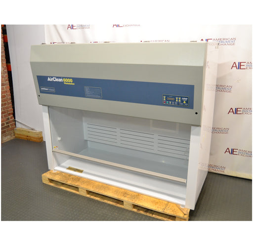 Left angled perspective view of an AirClean Systems AC6000S polypropylene ductless fume hood mounted on a wooden shipping pallet, showing its upper filter unit, control interface, and clear front workspace