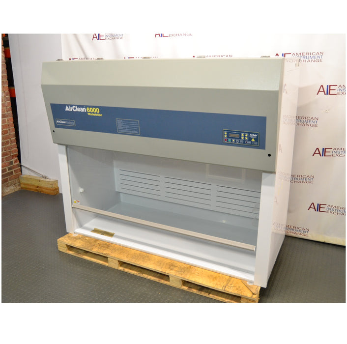 Left angled perspective view of an AirClean Systems AC6000S polypropylene ductless fume hood mounted on a wooden shipping pallet, showing its upper filter unit, control interface, and clear front workspace