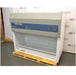 Left angled perspective view of an AirClean Systems AC6000S polypropylene ductless fume hood mounted on a wooden shipping pallet, showing its upper filter unit, control interface, and clear front workspace