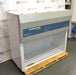 Right angled perspective view of an AirClean Systems AC6000S polypropylene ductless fume hood positioned on a wooden shipping pallet, showing its side panel, upper housing, and work chamber