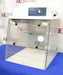 Front eye-level view of an AirClean Systems AC624LFUV PCR workstation sitting on a blue protective cloth, highlighting its clear acrylic enclosure, folding front sash, and digital-free control panel housing