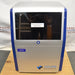 Front product view of an Azure Biosystems 200 gel imaging workstation, featuring a silver and blue housing, a dark viewing door window with a warning sticker, the model 200 label, and the company logo on the lower front panel
