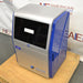 Right three-quarter angle product view of an Azure Biosystems 200 gel imaging workstation, highlighting the glossy blue side panel, silver front housing, dark viewing door, and brand logo on a wooden pallet base