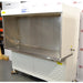 Right angled perspective view of Baker Edgegard EG6320 laminar flow clean bench showing open hood workspace, rear diffuser screen, stainless steel countertop, and side panel valve connections