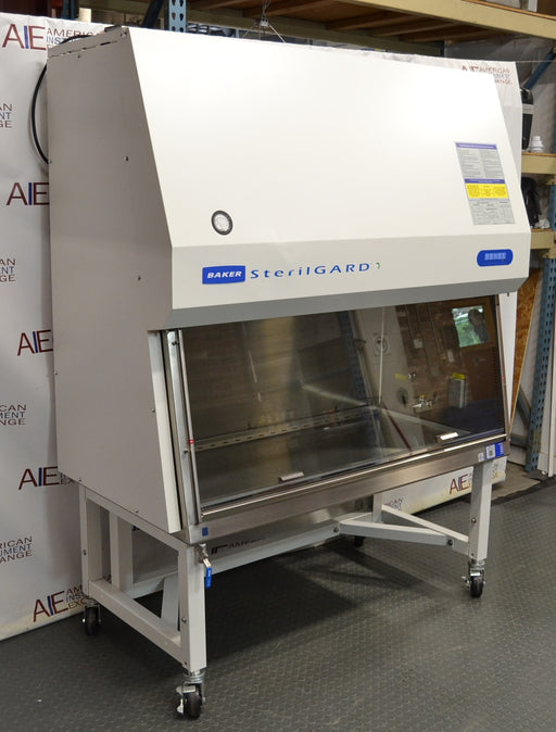 Front angled perspective view of a Baker SterilGARD e3 SG504 biosafety cabinet mounted on a locking caster stand, featuring a white exterior housing, sloped front sash with a stainless steel work zone, and blue brand graphics