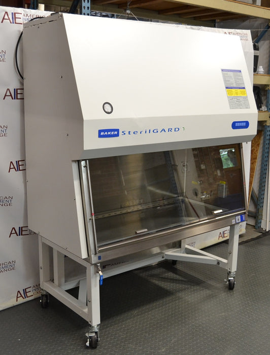Front angled perspective view of a Baker SterilGARD e3 SG504 biosafety cabinet mounted on a locking caster stand, featuring a white exterior housing, sloped front sash with a stainless steel work zone, and blue brand graphics
